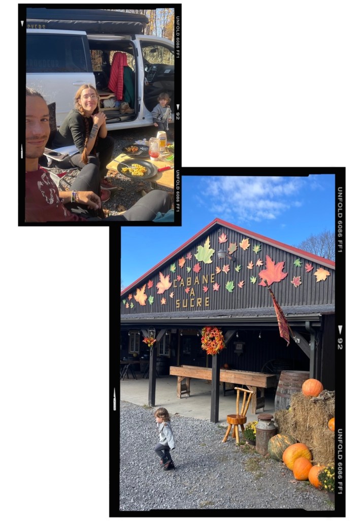 Un couple et un enfant dégustent un repas à l'extérieur près d'un van, avec une cabane à sucre décorée de feuilles d'automne et de citrouilles en arrière-plan.